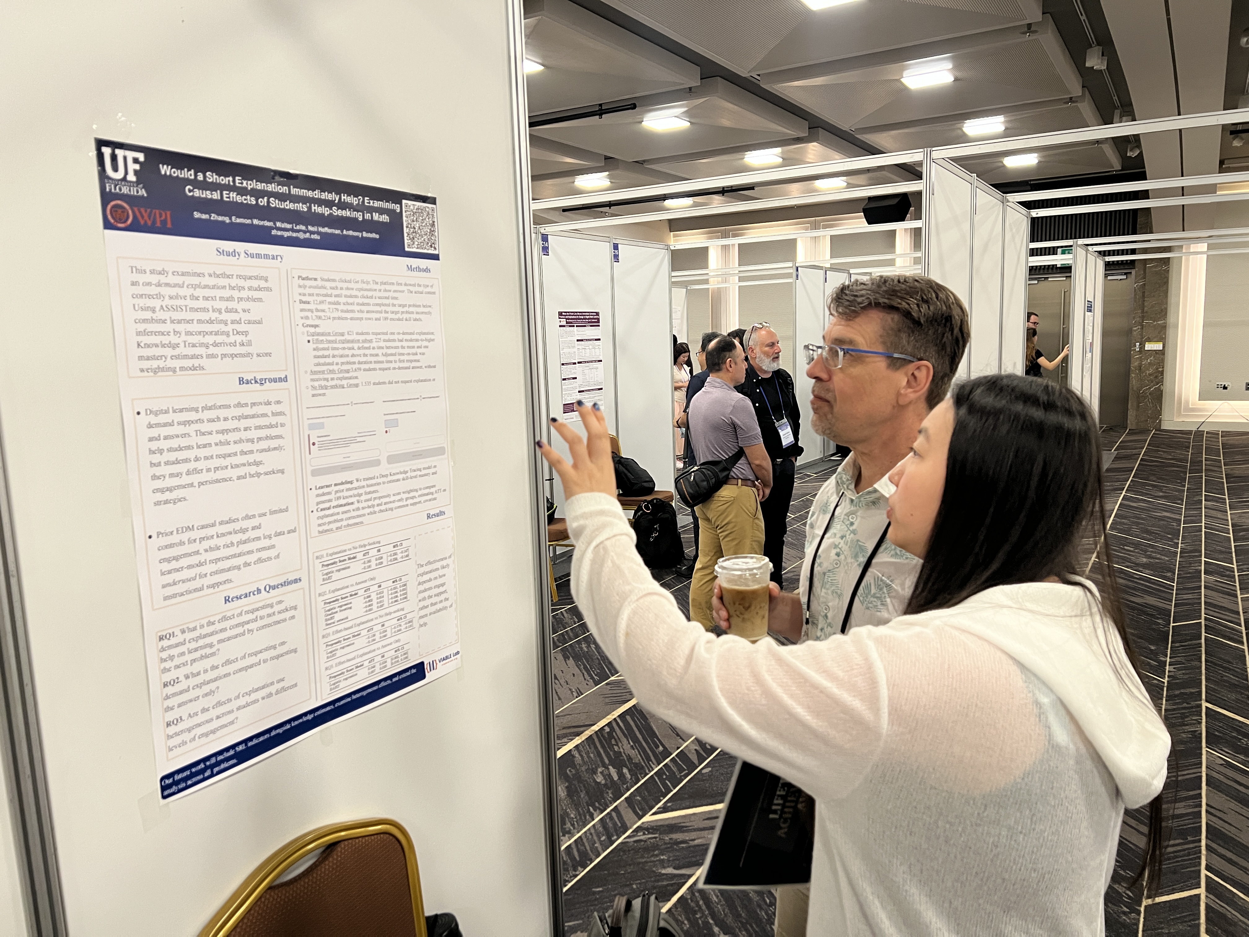 Shan Zhang discussing the EDM 2026 help-seeking poster with Ken Koedinger